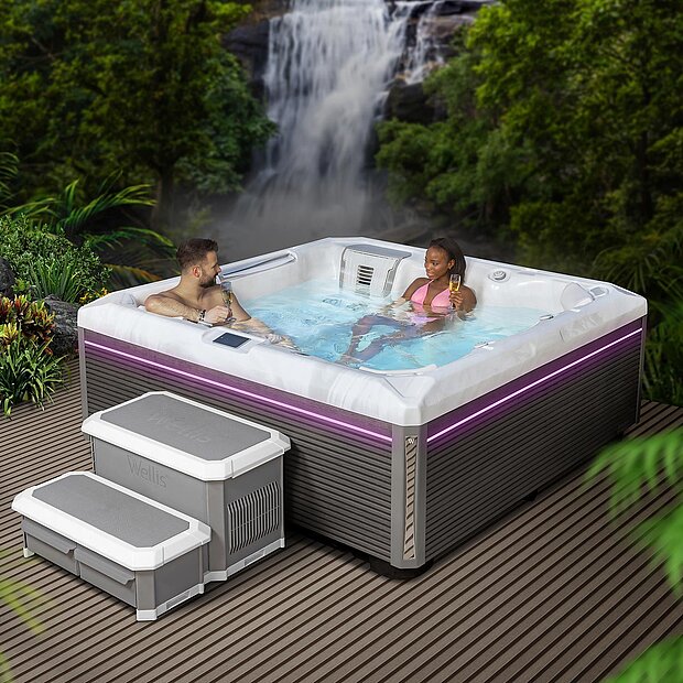 Frau in einem Whirlpool, der vor einem Wasserfall steht