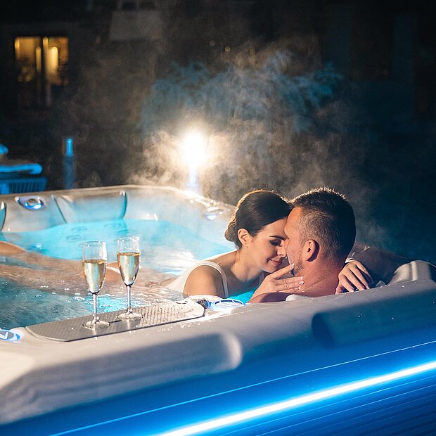 Zwei Personen in einem Whirlpool bei Nacht