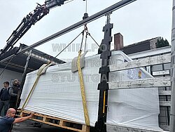 Menschen machen einen Swimspa an einem Kran fest